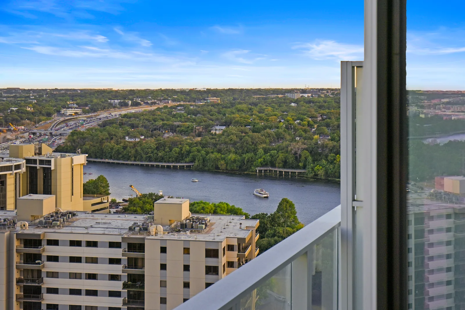 View from the balcony over a wooded stretch of water and nearby buildings