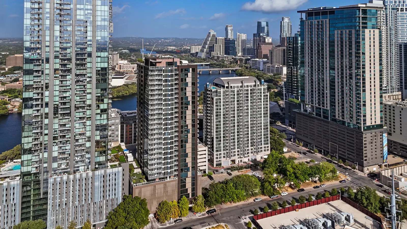 Aerial view of Rainey Street area towers with Lady Bird Lake and the downtown Austin skyline behind